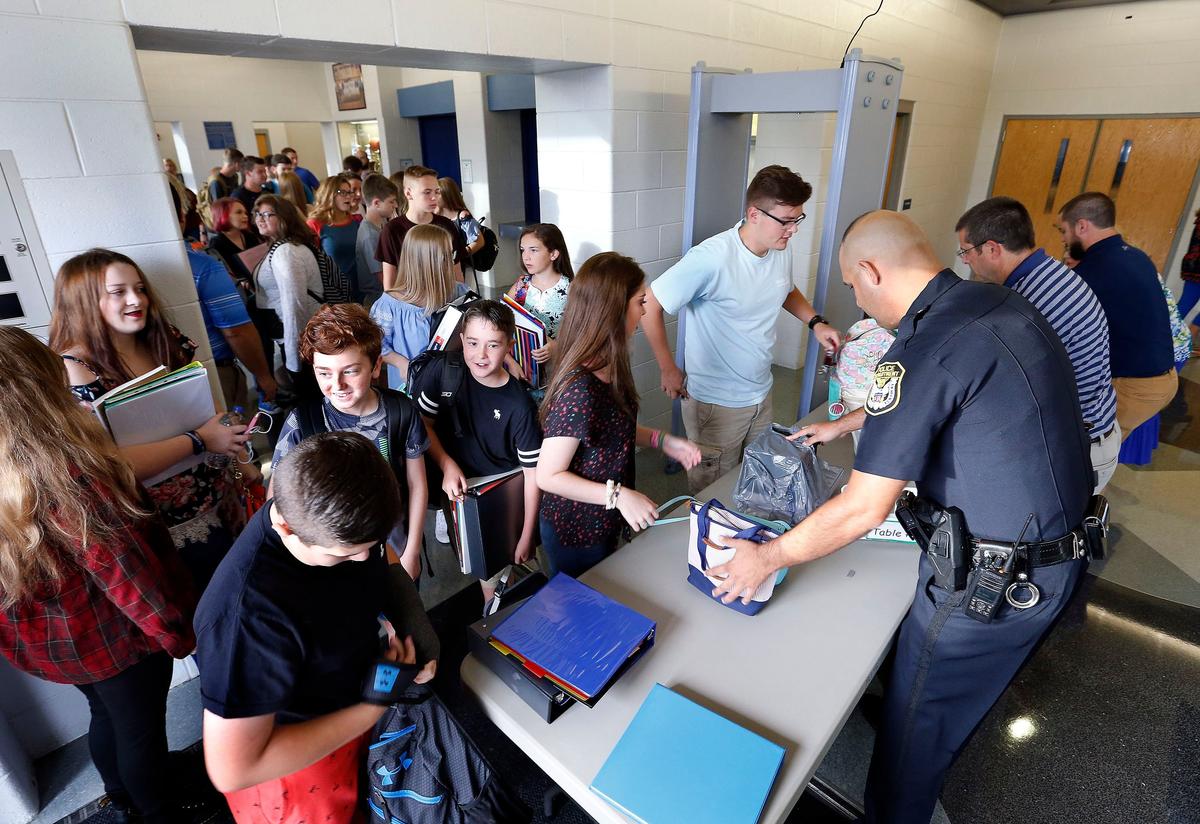 Barbourville Police Department Officer Adam Townsley, along with teachers, checked backpacks before students went through a metal detector on the first day of school Thursday morning at Barbourville High School. Barbourville Independent schools is one of three school districts that took Attorney Shane Romines up on his offer that he would buy walk-through metal detectors for area schools.