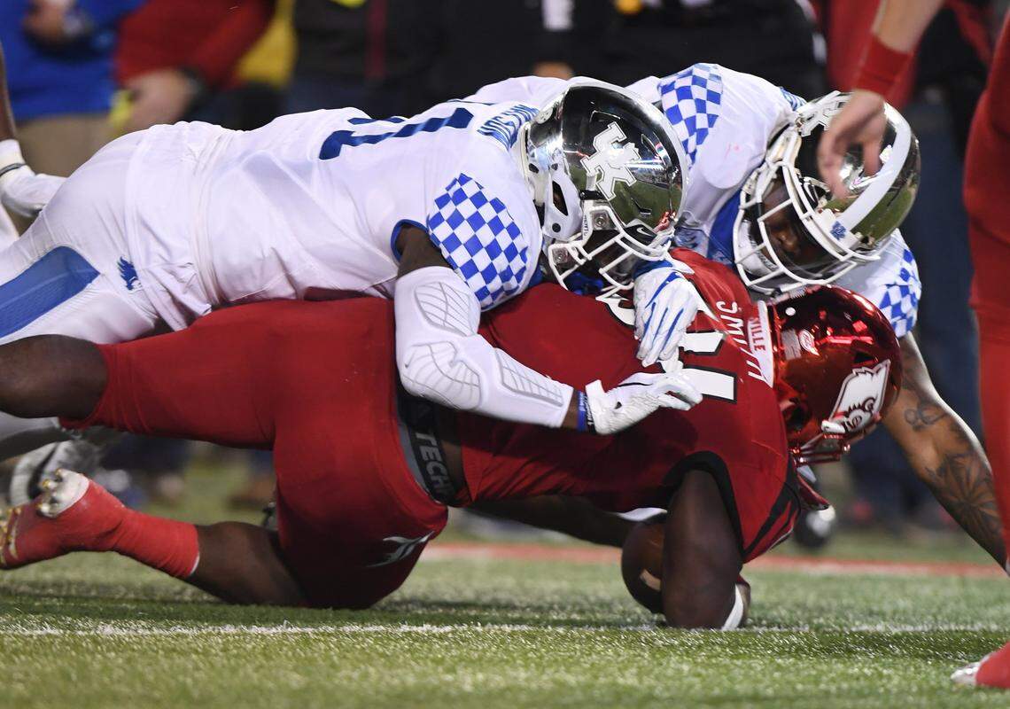 Kentucky’s Calvin Taylor, right, and Boogie Watson, left, tackled Louisville running back Jeremy Smith during the Wildcats’ 56-10 win over the Cardinals in 2018.