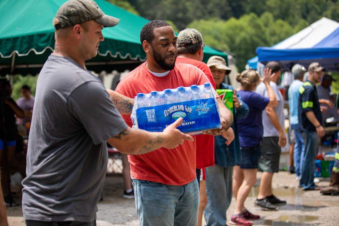 Representative Charles Booker, D-Louisville, helped carry donated water Wednesday for miners in Harlan County who were protesting on train tracks after their former employer, Blackjewel, failed to pay them for their last three weeks of work.