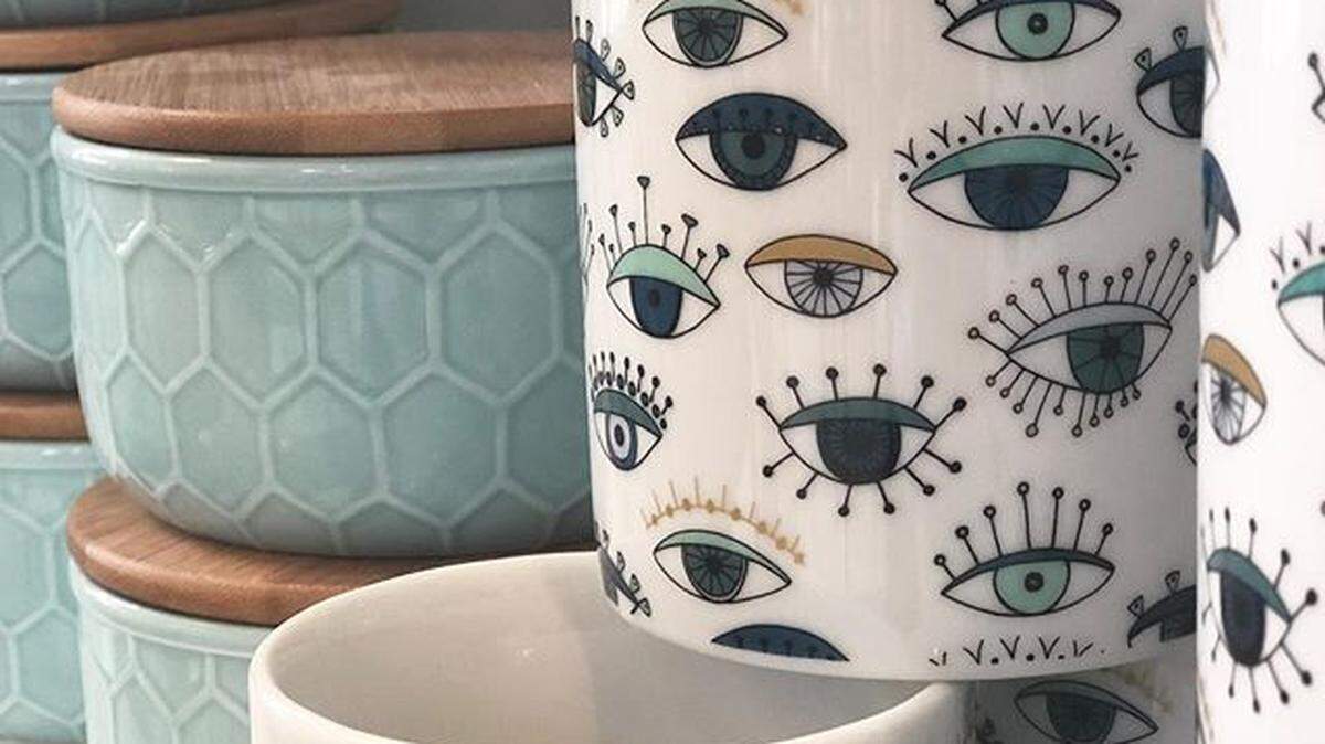 Kitchen accessories at Story, a new Lexington boutique, include these wood-top canisters. Alas, the "eye" mugs are sold out.