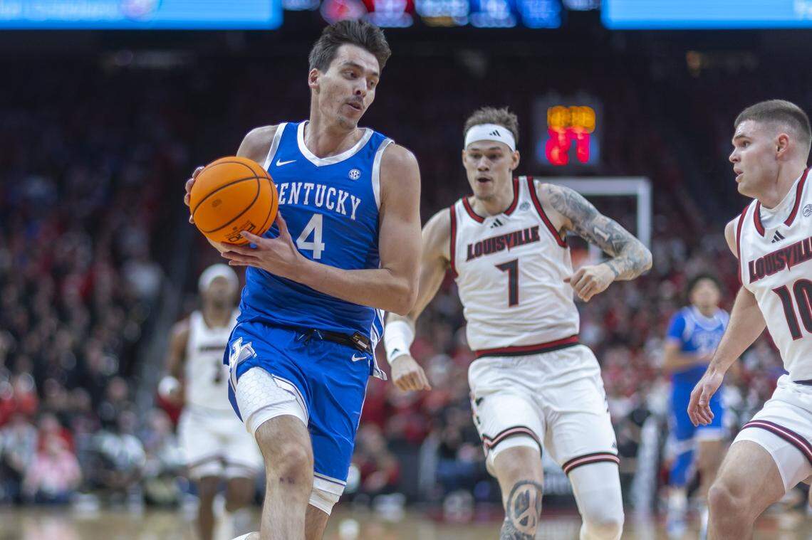 Kentucky forward Andrija Jelavic (4) drives the ball past Louisville forward Kasean Pryor (7) during Tuesday’s game at the KFC Yum Center in Louisville.
