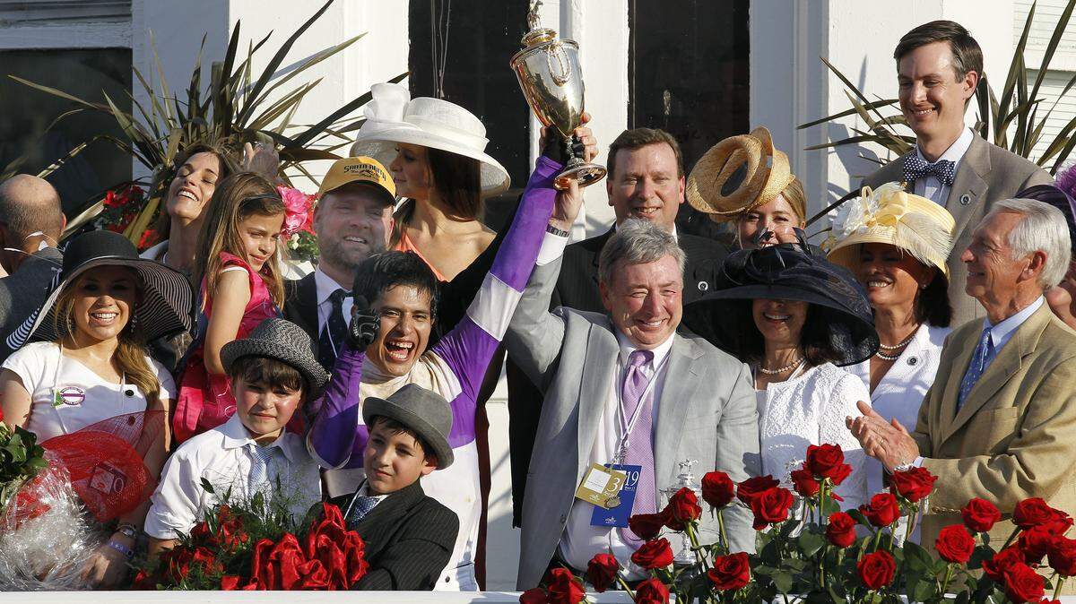 I'll Have Another's jockey, Mario Gutierrez, and owner J. Paul Reddam held up the Kentucky Derby trophy Saturday, flanked by trainer Doug O'Neill, behind Gutierrez, and Gov. Steve Beshear, right.      