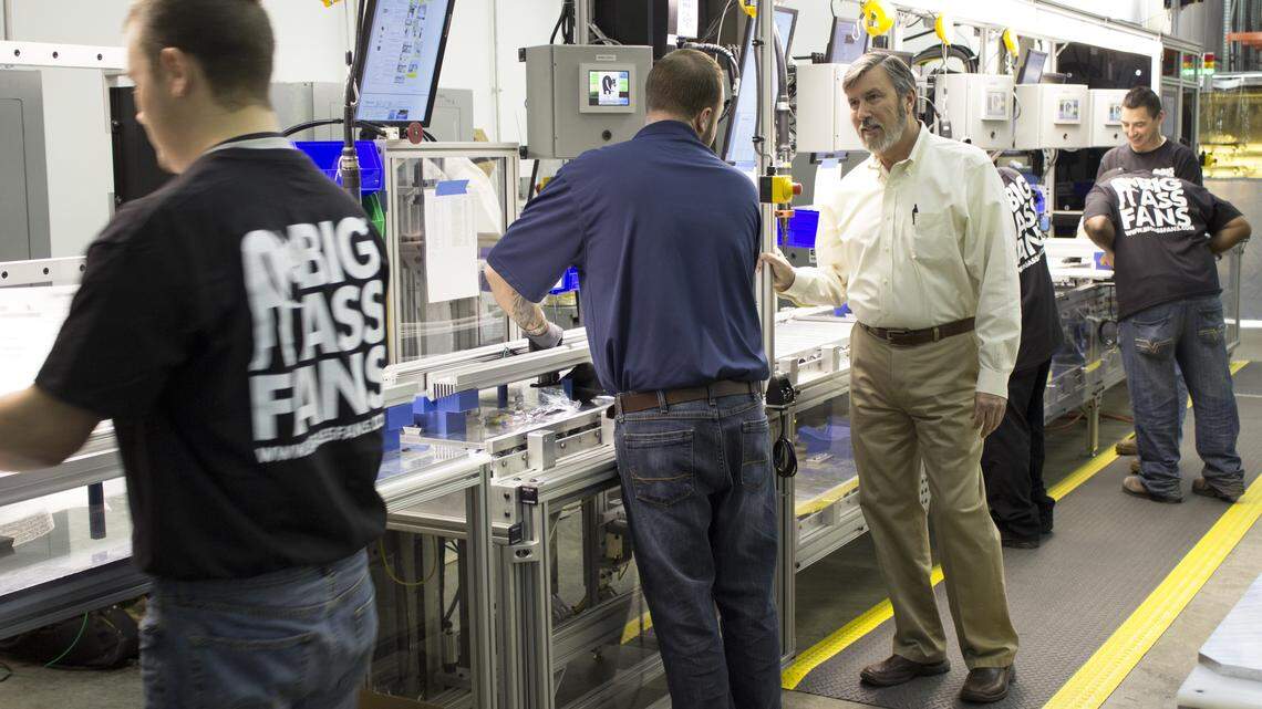 Big Ass CEO Carey Smith, right, spoke with team leader Jared Shields along the company's new Big Ass High Bay LED light fixture assembly line in Lexington. The new division was launched early this month.  