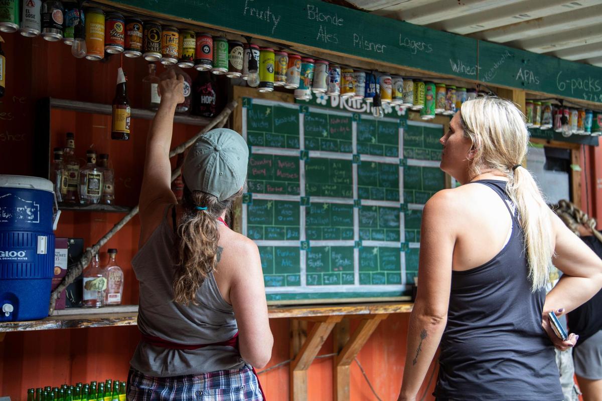 April Reefer, owner of Hop’s Beer Garden, gives recommendations Aug. 14 of the more than 100 beer options offered at the Red River Gorge restaurant.