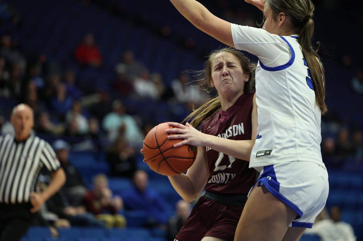 Graci Risley (21) of Henderson County is cut off on her way to the basket during Thursday night’s game in Rupp Arena.