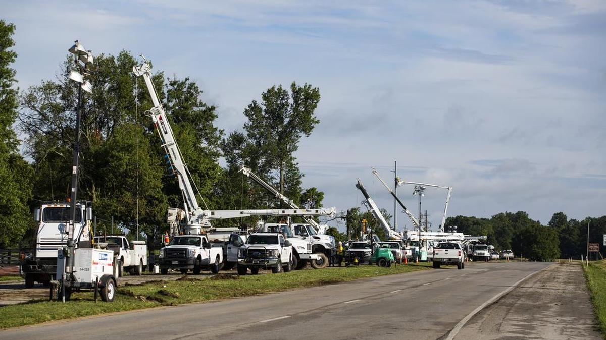 More than 10 crane trucks work on power lines and fallen trees along US 60 heading into Versailles on Saturday morning after violent storms and wind caused damage on Friday evening. 