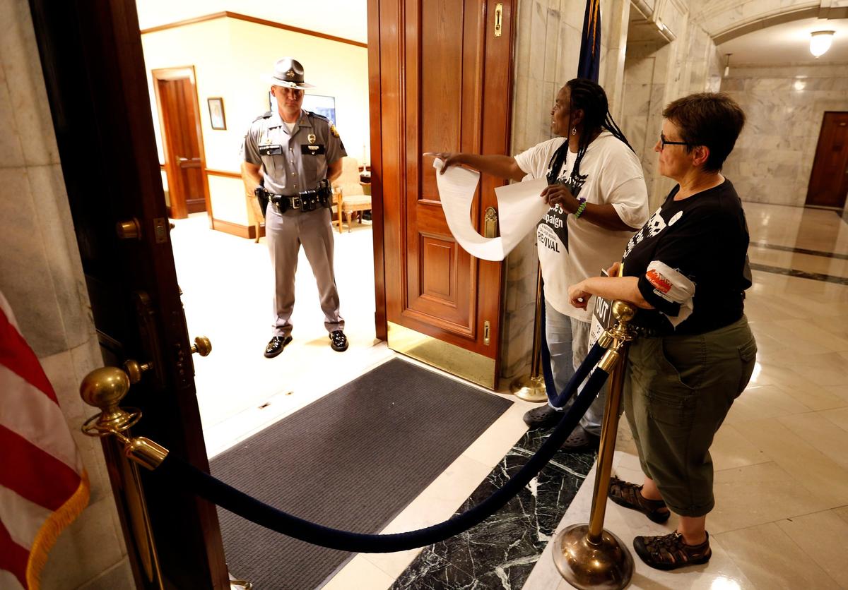A Kentucky State Police sergeant stood guard in the governor's office as Tayna Fogle, middle, and Pam McMichael, right, attempted, unsuccessfully, to gain access to the office to deliver a petition Monday afternoon.