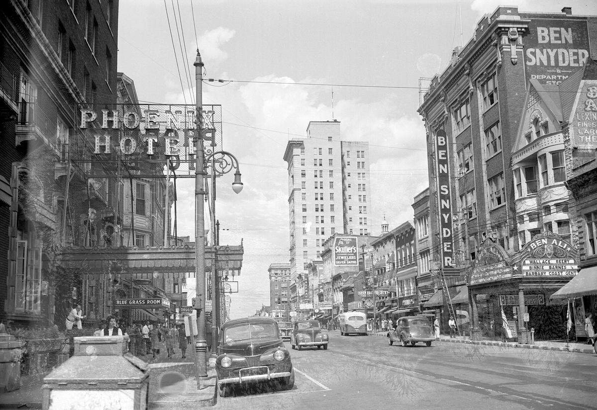 Downtown view of Lexington, looking west down East Main Street, cira 1944. On the left is the landmark Phoenix Hotel, which was demolished in 1981 and 1982 by Wallace Wilkinson, who planned to use the site to build the World Coal Center skyscraper. It was never built, and the site eventually became the Park Plaza Apartments and Phoenix Park. Up the right side is the Ben Ali Theater, which opened in 1913 at 121 East Main Street, across the street from the Phoenix Hotel. At four stories tall. It had a main auditorium, a balcony and a gallery, and 12 private boxes on each side, for a total seating capacity of 1,507. It was torn town in 1965. Today it is the site of the Robert F. Stephens Courthouse Plaza. Next to the theater is the Ben Snyder department store. The store was founded in 1913 and had locations in Louisville, Paducah, Elizabethtown, Bowling Green and southern Indiana. This location operated from 1935 until 1980.