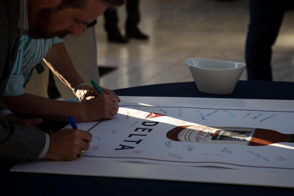 Guests sign a sheet at the entrance with the Delta logo and an image of a Miss Marie’s Spaghetti Sauce during an announcement event held at the Carrick House in Lexington, Ky., Wednesday, October 20, 2021. Sichko says he “wanted a sauce where the proceeds were also going to feed others.”