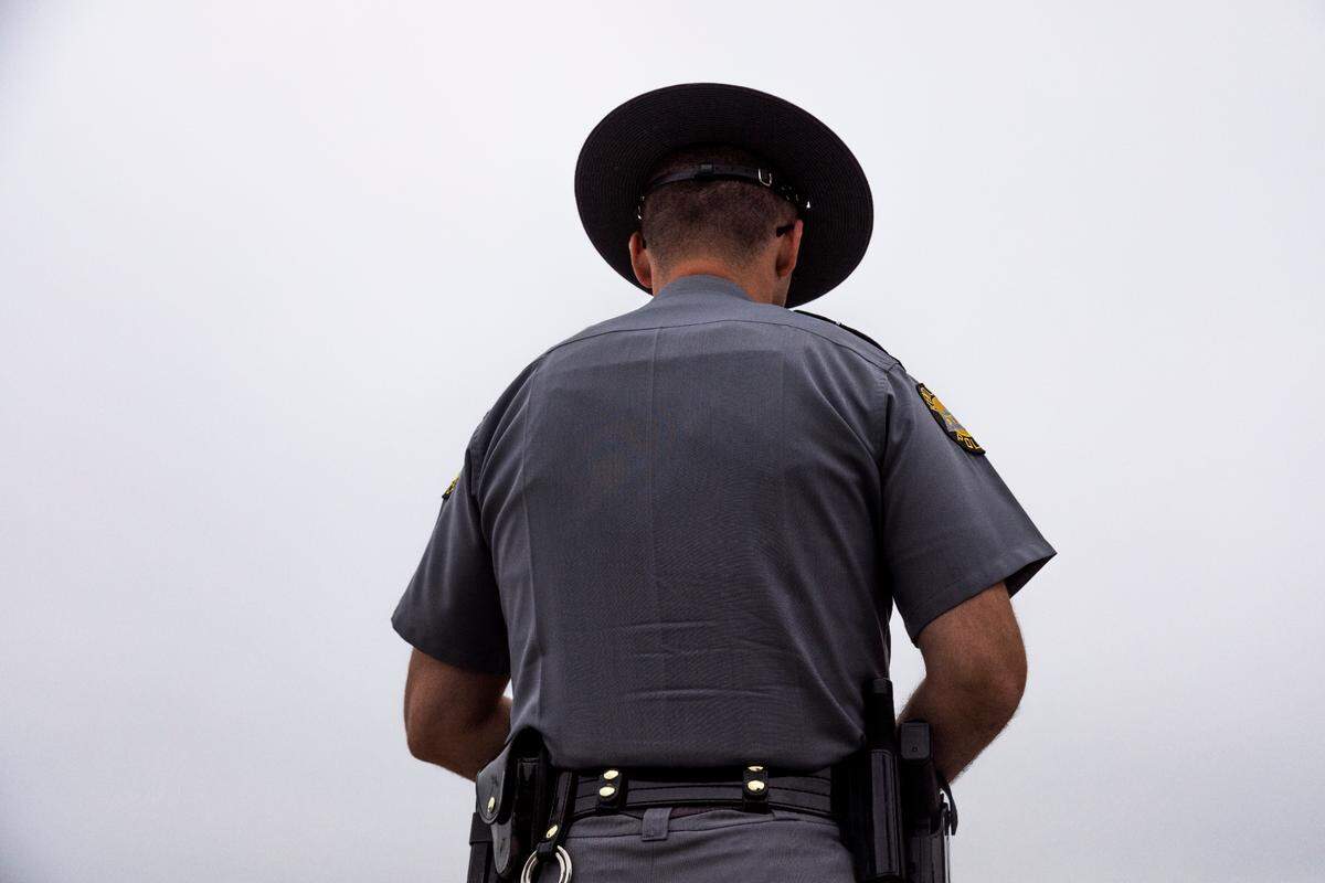 Kentucky State Police officer in hat.