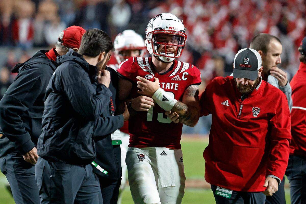 Quarterback Devin Leary is assisted off the field by medical staff during North Carolina State’s game against Florida State on Oct. 8. The torn pectoral muscle tear on his right side ended Leary’s season.