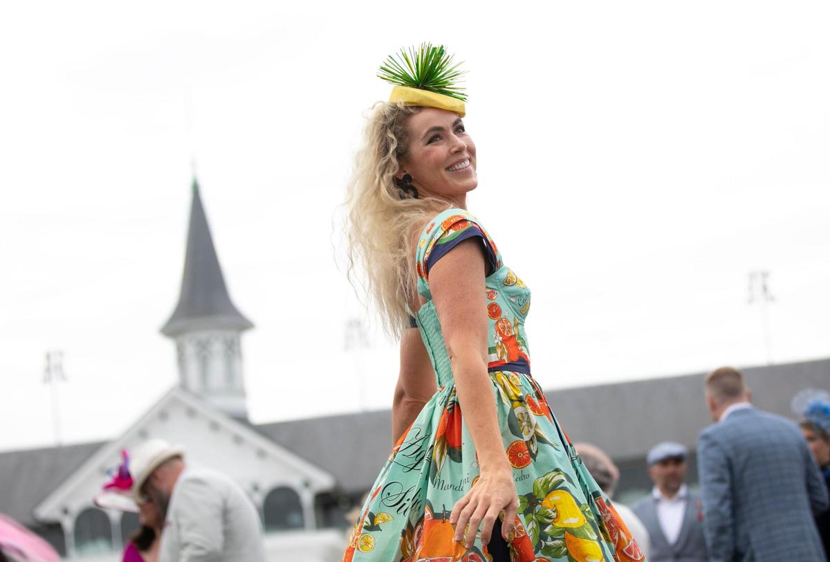 Qwynne Winslow, from Florida, wears a bright citrus themed dress to her first Kentucky Derby at Churchill Downs in Louisville, Ky., Saturday, May 6, 2023. She purchased her fascinator from a shop in her hotel lobby.
