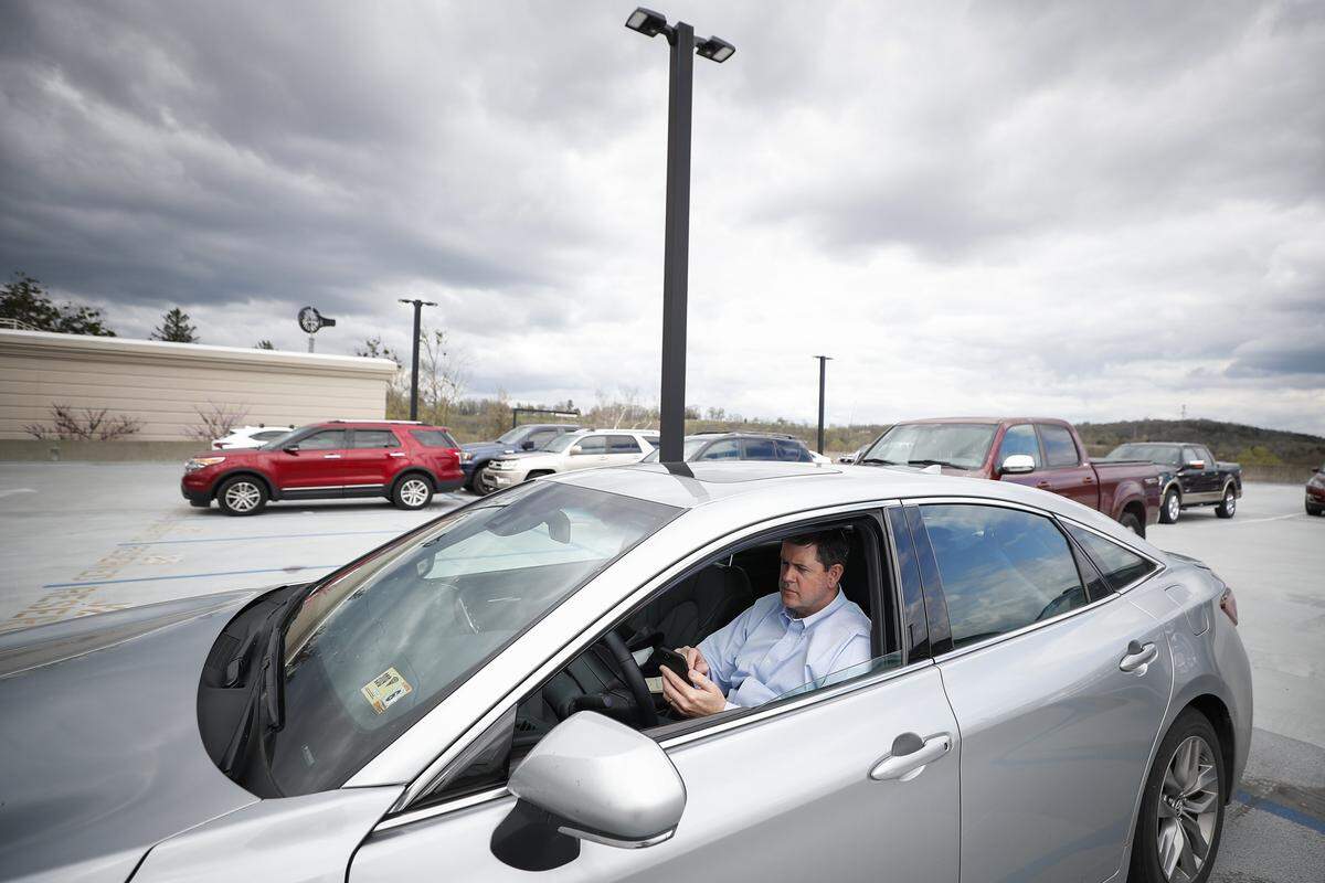 Rep. Chris Harris, D-Pikeville, waits to vote on a bill from the parking lot in an effort to protect himself from COVID-19 during a Kentucky House floor session at the state Capitol In Frankfort, Ky., Wednesday, April 1, 2020. House members were allowed to vote by paper ballots or over the phone.