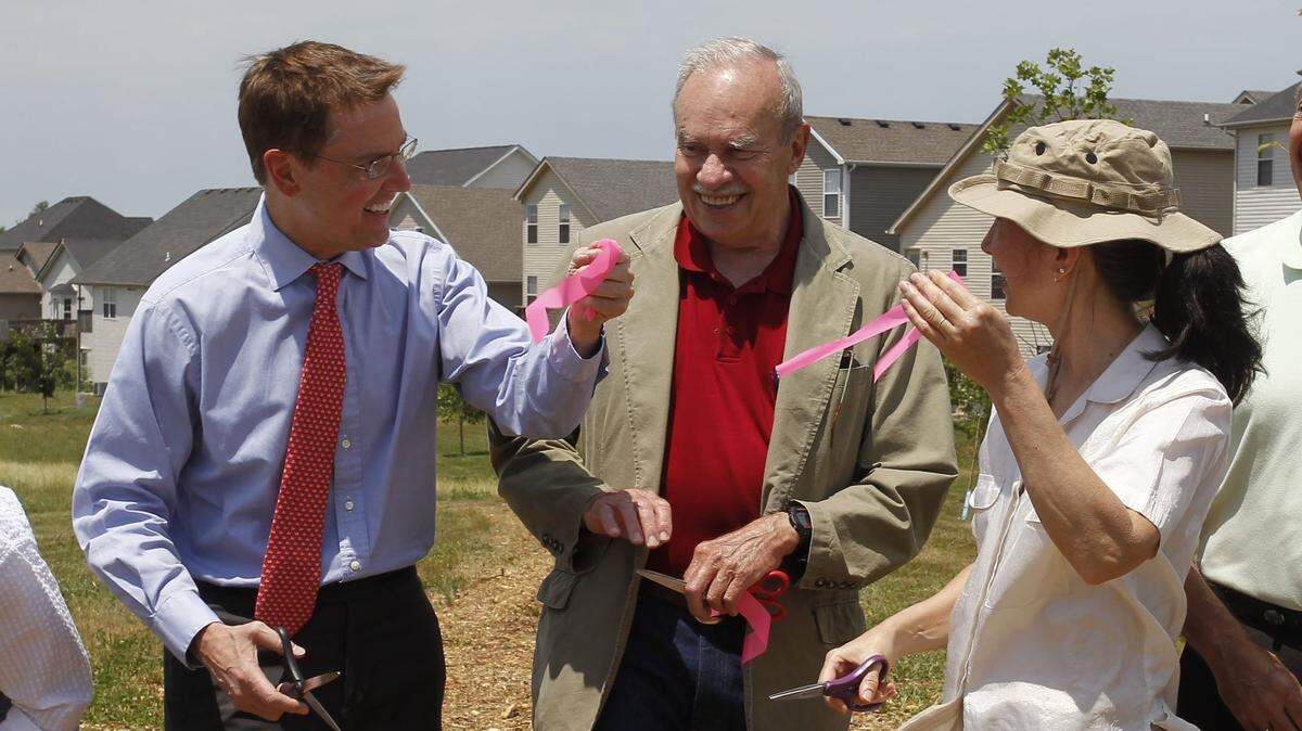 Lexington Mayor Jim Gray, held up his part of the ribbon, for Council member Tom Blues, center, and D.G. Gridley, right, a member of the McConnell’s Trace Neighborhood Association, during the opening of McConnell’s Trace Greenway, a 1,500 foot walking path on Thursday May 31, 2012.