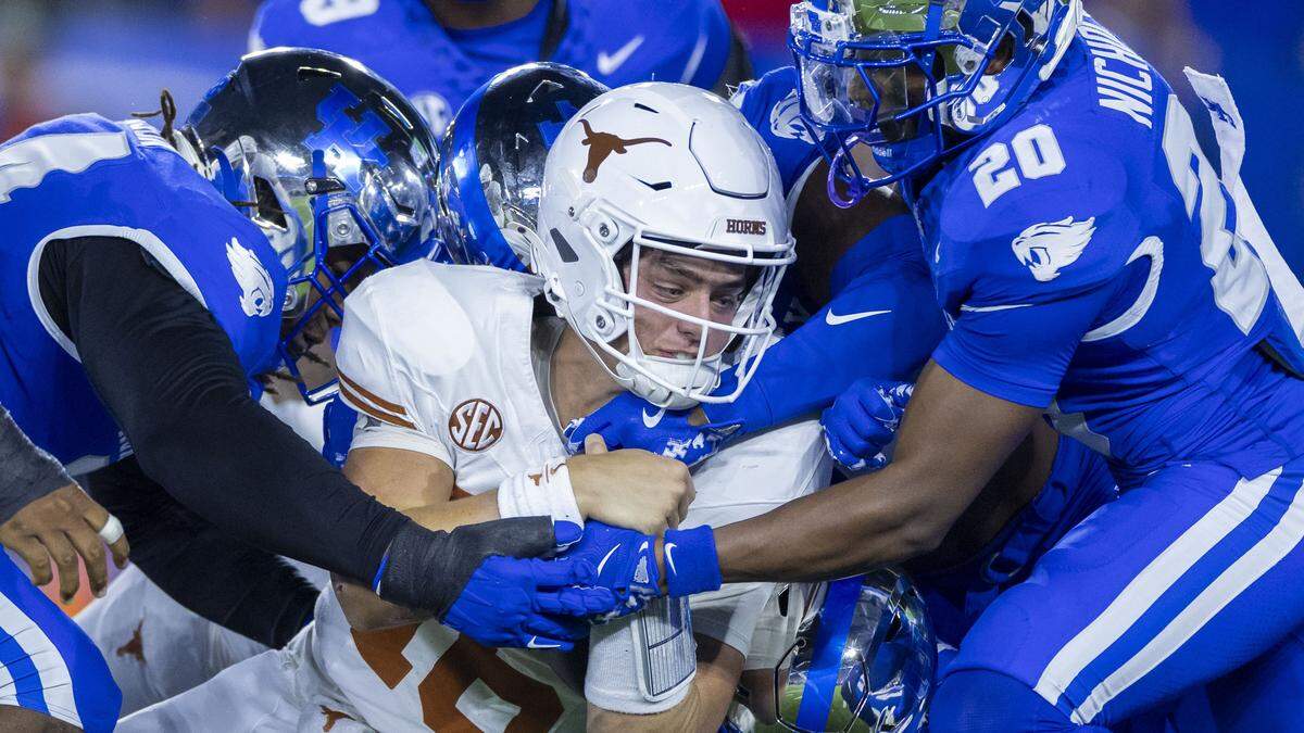 Texas quarterback Arch Manning (16) drives toward the goal line as the Wildcats’ defense, led by defensive back Terhyon Nichols (20) tries to stop him during Saturday’s game against Texas.