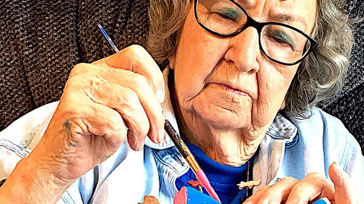 Minnie Adkins paints a sculpture. Photo by Mike Norris