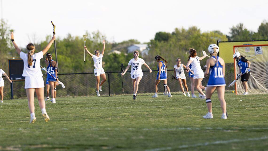 Sayre’s Kathryn Kinder (26) and her teammates celebrate her buzzer-beating go-ahead goal at the end of the third quarter during the Spartans’ 10-5 win over Lexington Catholic as the Sayre Athletic Complex on Thursday.