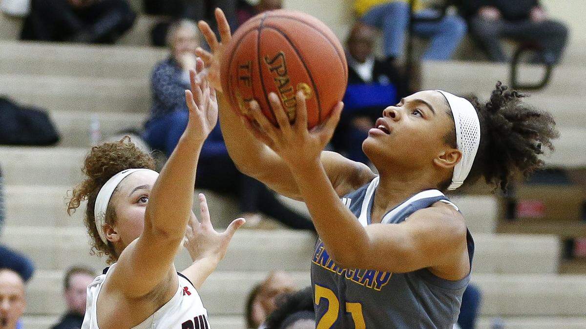 Henry Clay’s Amiyha Jenkins (21) went up against Paul Laurence Dunbar’s Elise Ellison-Coons (5) during their game Thursday at Paul Laurence Dunbar High School in Lexington. Henry Clay beat Paul Laurence Dunbar 58-51.