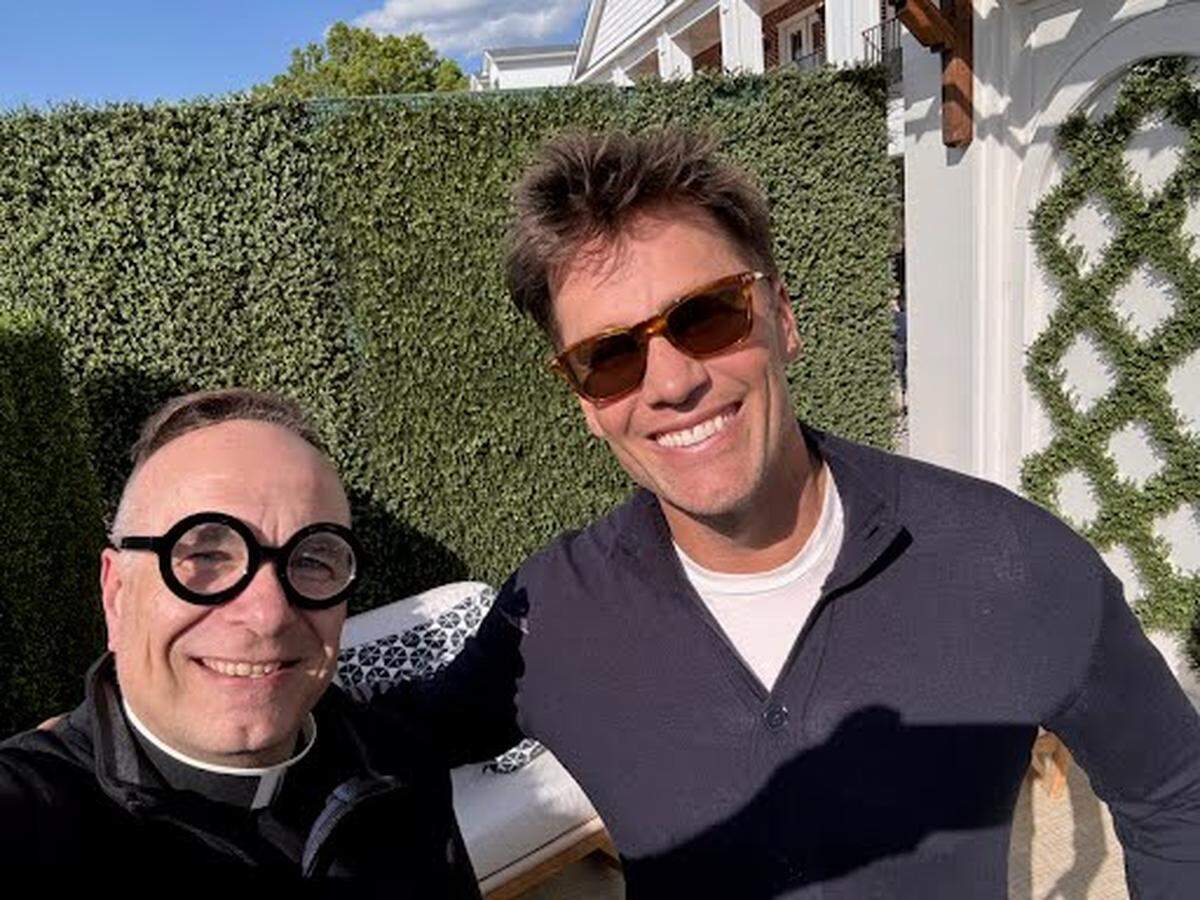 Father Jim Sichko with former New England Patriots quarterback Tom Brady, who also signed a bottle of Willett bourbon that will be auctioned for charity.
