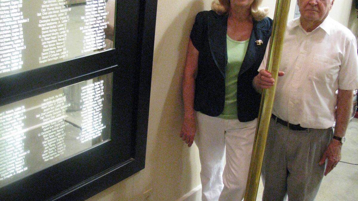 Julie and Bob Garvin stood by a brass sliding pole and a 9/11 plaque inside a replica firehouse created by Bob's son Harry. The pole was made in Somerville, Mass., on the morning of the attacks.  