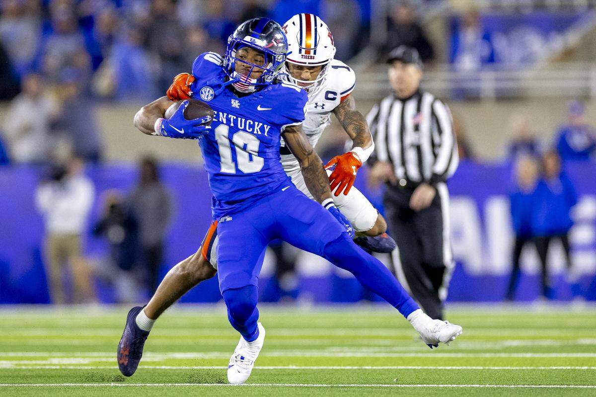 Kentucky running back Jamarion Wilcox (10) tries to escape Auburn’s Jerrin Thompson (1) during Saturday night’s game at Kroger Field. The Wildcats must win three of their final four games to earn bowl eligibility.
