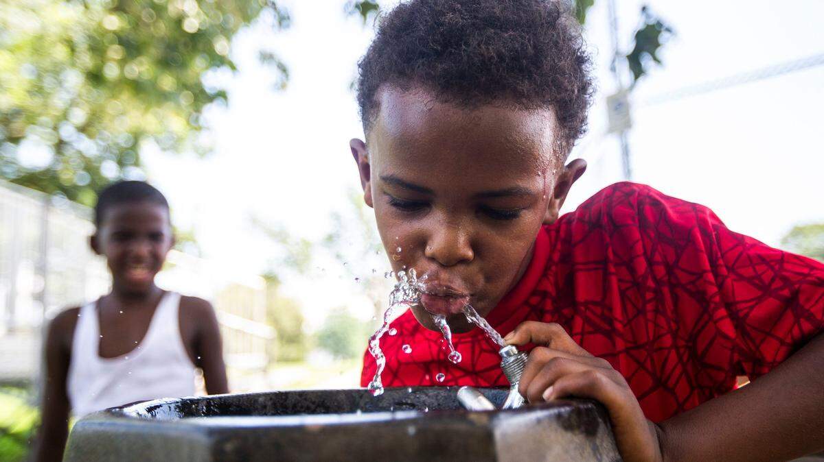 Jermarion Robertson, 9, puts his finger over the spout of a water fountain while taking a drink at Castlewood Park on last July during a day the National Weather Service said the heat index reached 103¼ F.