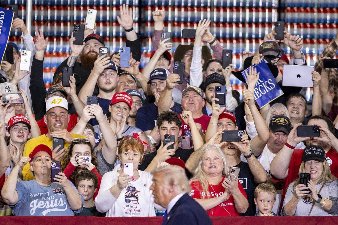 People record President Donald Trump as the song “YMCA” played during his visit to Verst Logistics in Hebron, Kentucky, on Wednesday, March 11, 2026.