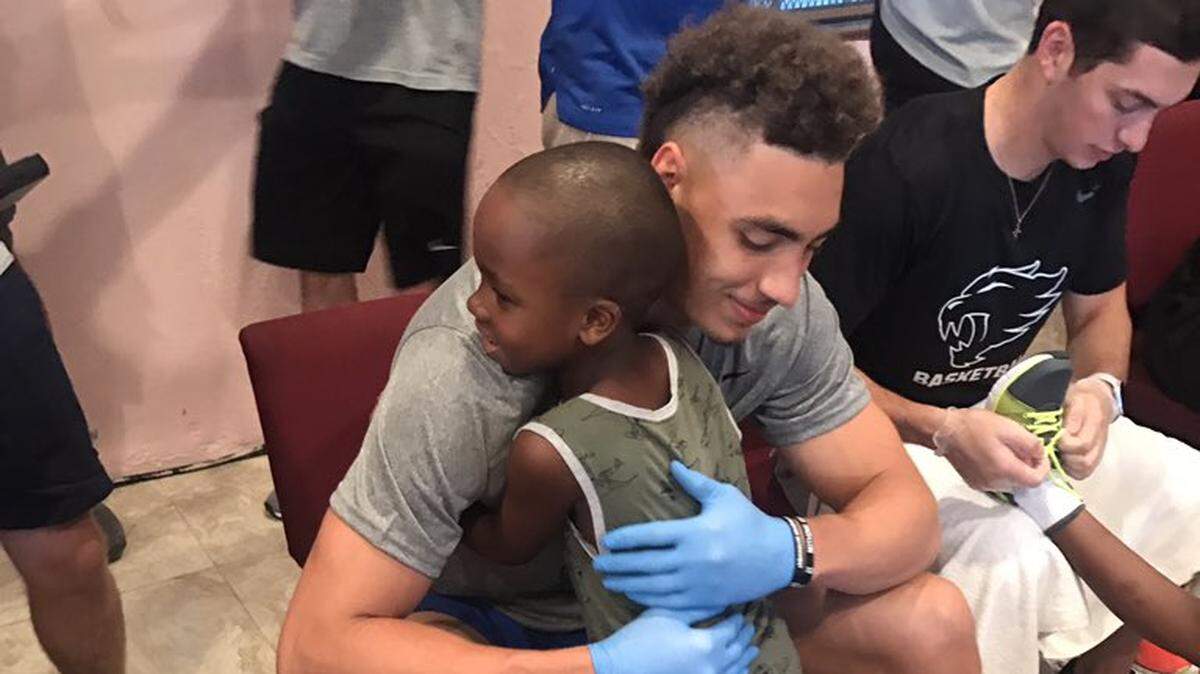 Kentucky’s Reid Travis hugged one of the children receiving new shoes from Samaritan’s Feet, a charity that provides shoes to under-served children around the world. Travis and other UK players washed each child’s feet before providing them with new socks and shoes.