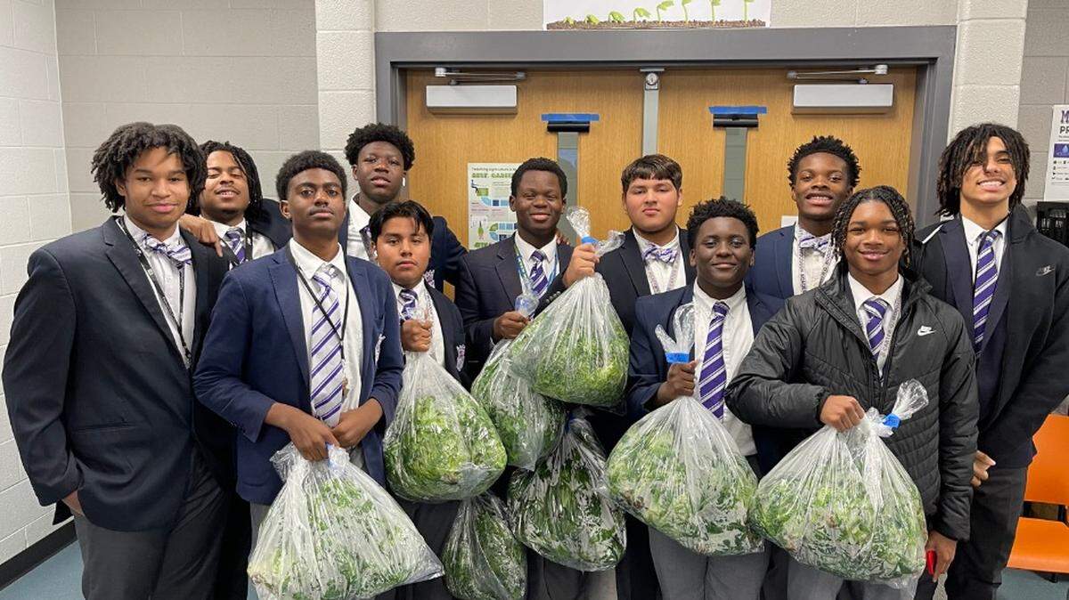 Students at Carter G. Woodson Academy in Lexington show off their lettuce crop. 
