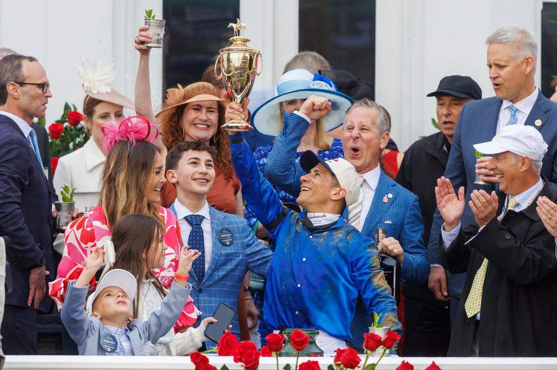 Winning Jockey Junior Alvarado, joined by his family, hoists the trophy after Sovereignty prevailed in the Kentucky Derby.