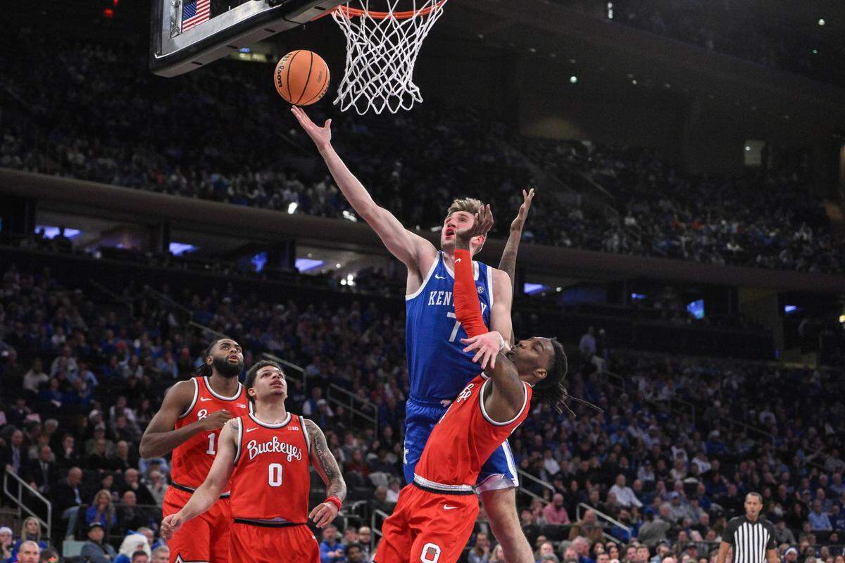 Dec 21, 2024; New York, New York, USA; Kentucky Wildcats forward Andrew Carr (7) drives to the basket while being defended by Ohio State Buckeyes forward Aaron Bradshaw (4) during the first half at Madison Square Garden. Mandatory Credit: John Jones-Imagn Images