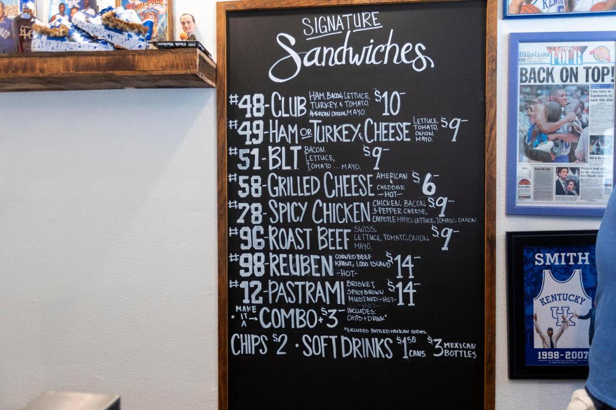 The menu board for the the Big Blue Deli plays off UK’s eight NCAA titles.