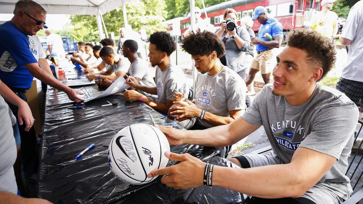 Reid Travis, right, signed autographs with other UK players during the Big Blue Caravan stop in Midway last week.