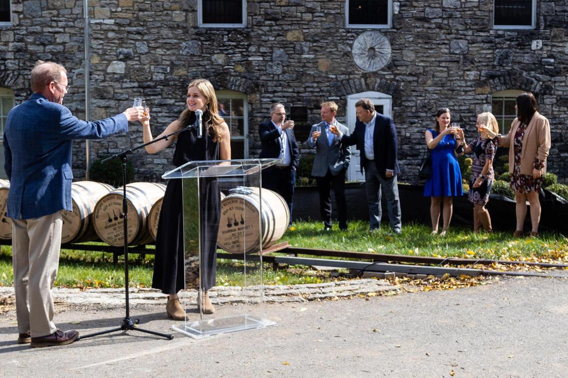 Woodford Reserve Master Distiller Chris Morris and Assistant Master Distiller Elizabeth McCall and other Woodford employees raise glasses in toast of the distillery’s 25th anniversary and to an expansion of their facility to double production capacity, October 12, 2021.