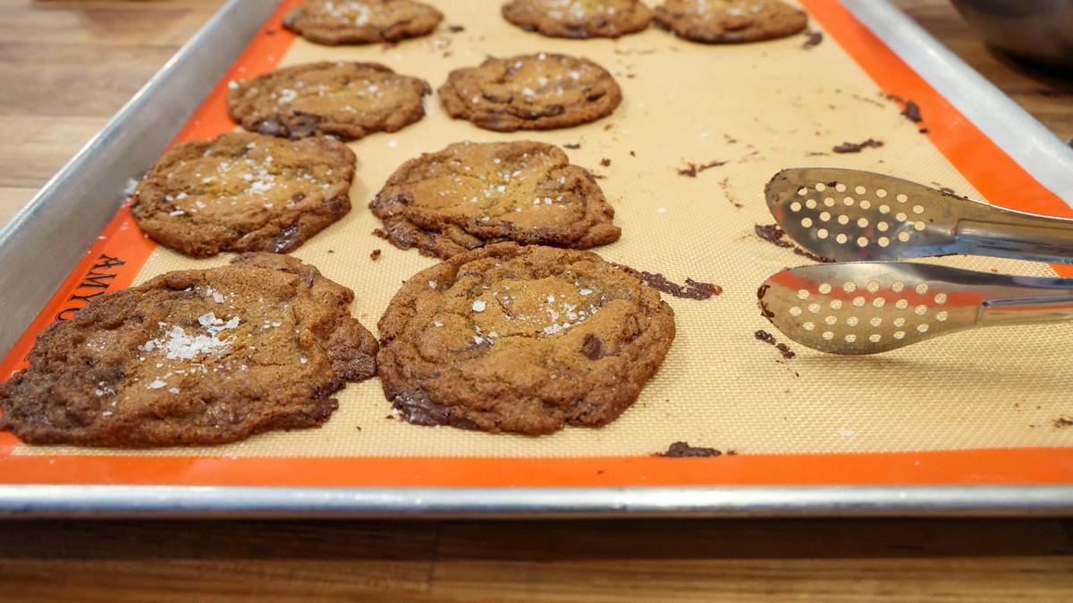 Chocolate chip + sea salt cookies rest on a baking sheet Thursday, Feb. 20, 2025 after coming out of the oven at Wild Lab Bakery in Lexington, Ky. The local bakery often sells out of the popular cookies, which are $3 a piece.