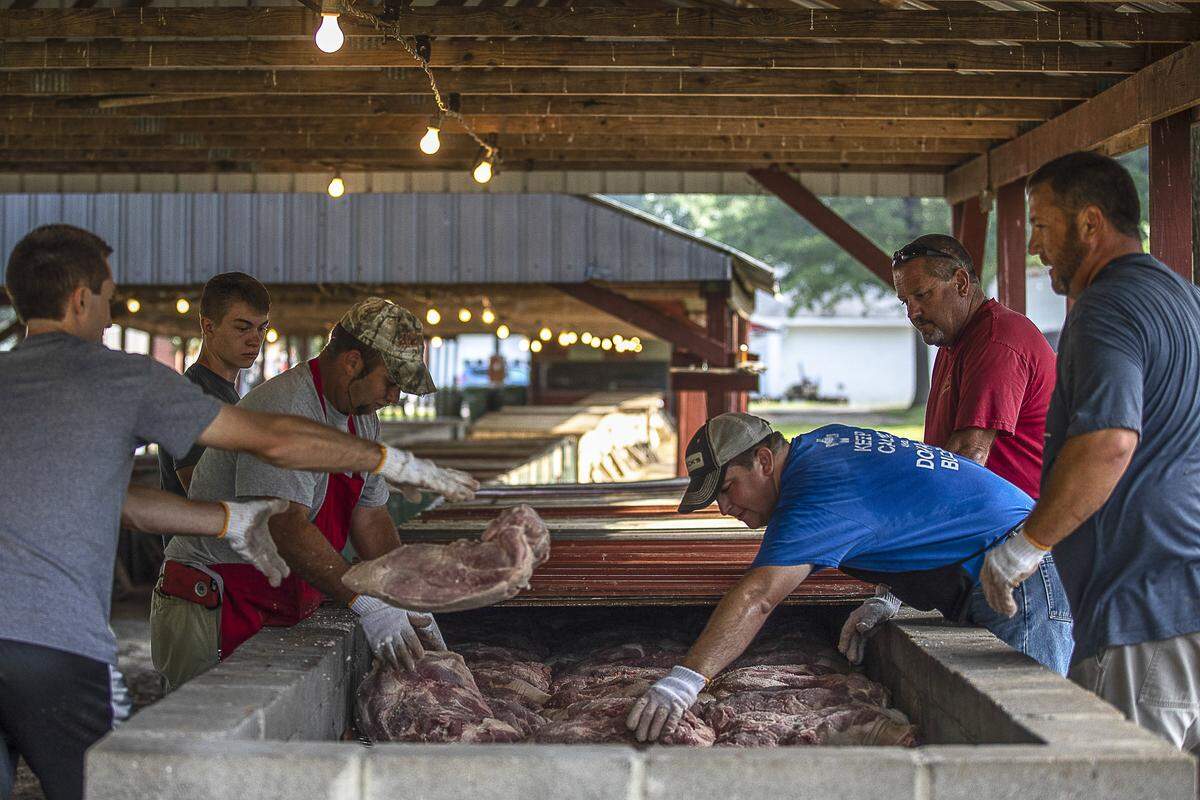 Pork is loaded on the barbecue pits on the grounds of St. Jerome Catholic Church in Fancy Farm, Ky., Friday, Aug. 2, 2019, in preparation of the Fancy Farm Picnic. Nine tons of pork and mutton are being prepared.