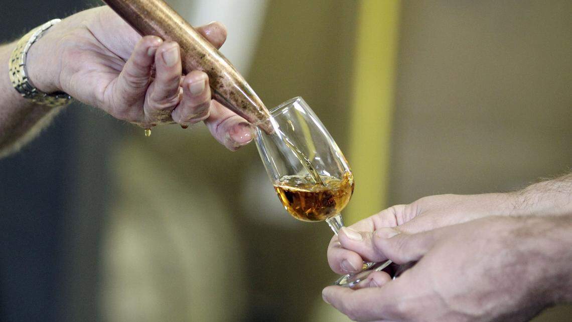 Four Roses Master Distiller Jim Rutledge poured a glass of one of the 10 Four Roses mash bills for Luke Ford to sample as he and others in a group from Seven Grand, a whiskey bar in Los Angeles and San Diego, selected two barrels of Four Roses straight bourbon for their bar, during a private barrel tasting and selection event at the Four Roses Warehouse and Bottling facility, in Cox’s Creek, Ky., Wednesday, September 18, 2013. The bourbon will be bottled and labeled with their personalized label. Photo by Charles Bertram | Staff