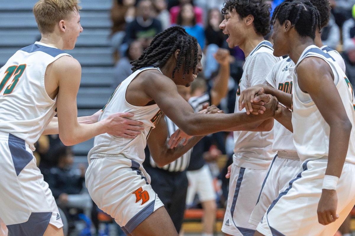 Frederick Douglass forward Aveion Chenault (10) is helped up off the court by his teammates after being fouled during a game against Bryan Station at Frederick Douglass High School on Wednesday.