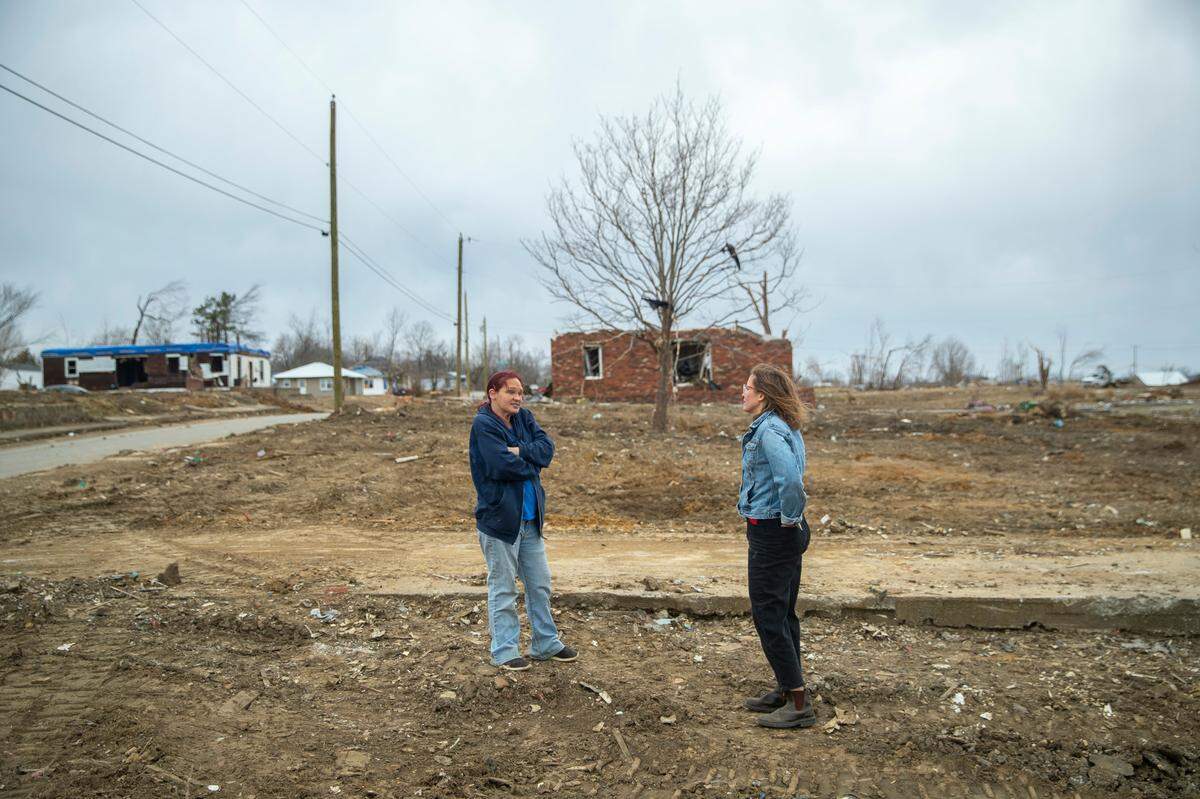Lexington Herald-Leader reporter Alex Acquisto, right, speaks with Toskia Adamson at the site of her mother’s home in Dawson Springs, Ky., Friday, Feb. 11, 2022. During the Dec. 10, 2021, historic quad-state tornadoes that scoured a path of destruction nearly 200 miles, most of which was in Kentucky, Adamson’s mother and son were sucked out of the home and flung into the air.