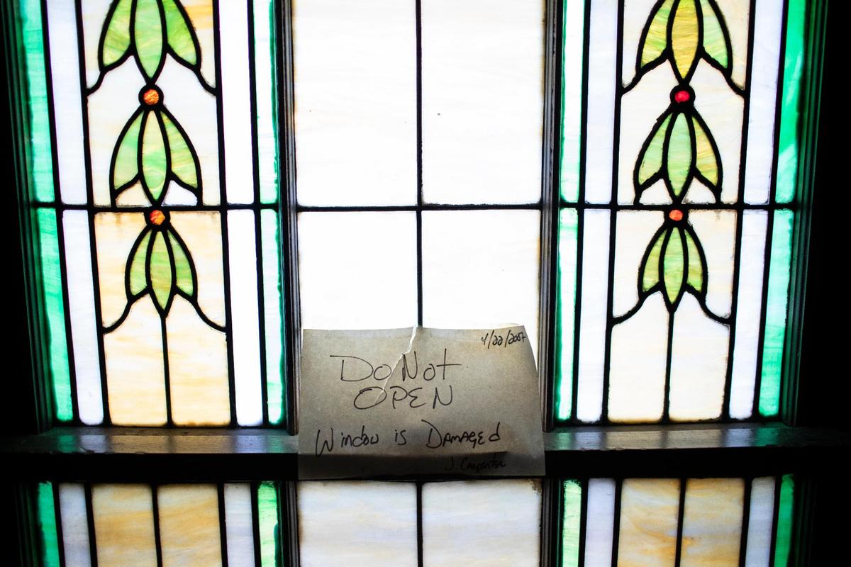 A window with a sign warning of damage at Woodland Christian Church.