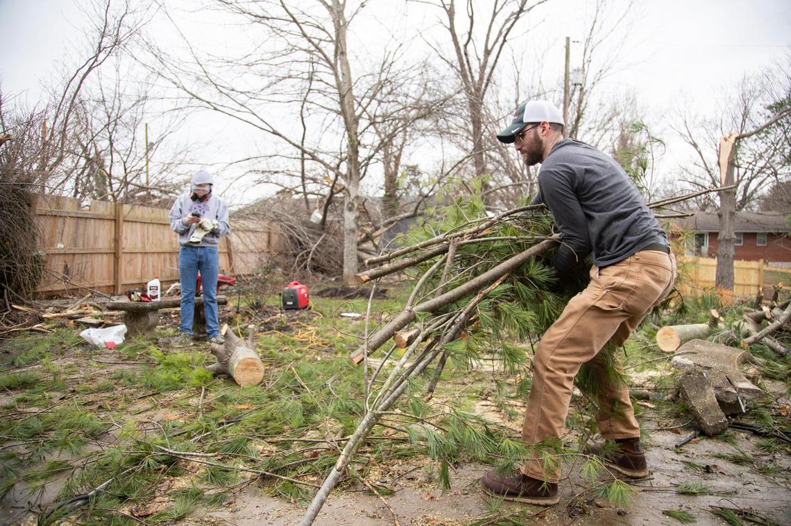 People work to clear debris and trees knocked over by tornadoes that came through the area laying on houses and in the streets at Bowling Green, Ky., Saturday, December 11, 2021. Severe storms passed through the state Friday night.