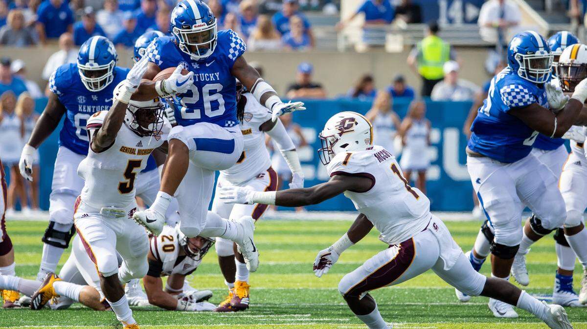 Kentucky running back Benny Snell broke through Central Michigan defenders Devonni Reed (5) and Alonzo McCoy (1) and raced to a 52-yard touchdown during the first half at Kroger Field on Saturday.