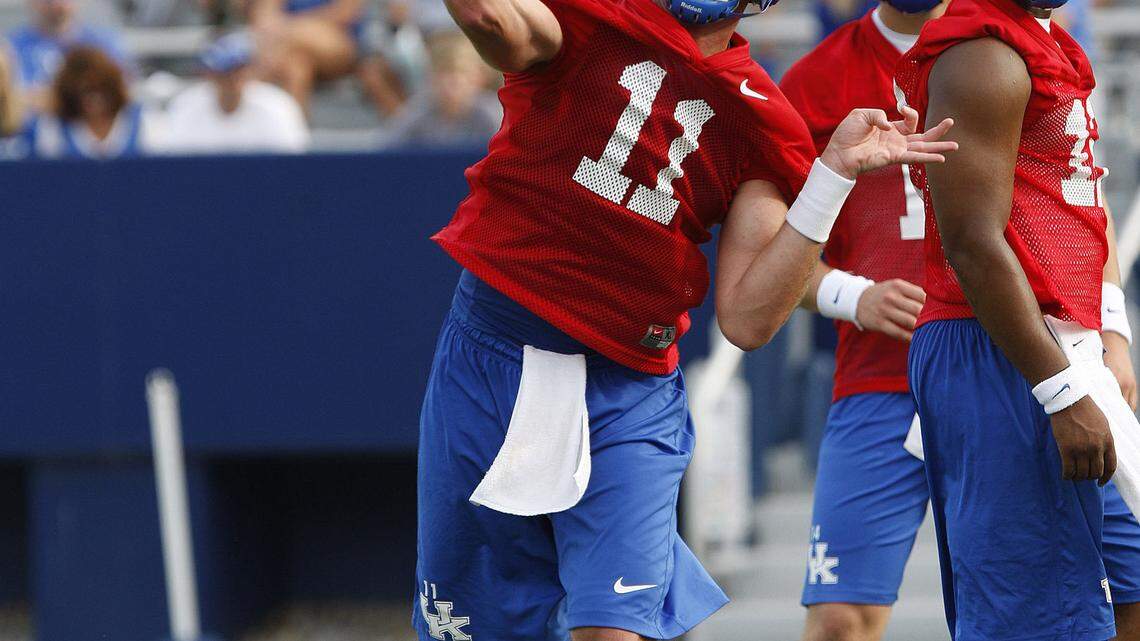 Maxwell Smith threw during special teams at UK's fan day on Aug. 4 as freshman Patrick Towles, center, and senior Morgan Newton looked on.  
