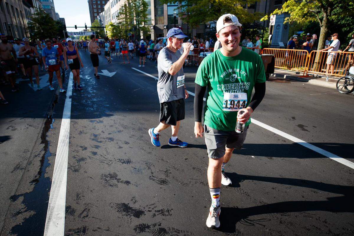 Herald-Leader sports reporter Cam Drummond smiles after crossing the finish line during Monday’s Bluegrass 10,000 in downtown Lexington. Drummond finished the 10K race, his first ever competitive race, with a time of 58 minutes and 38 seconds.