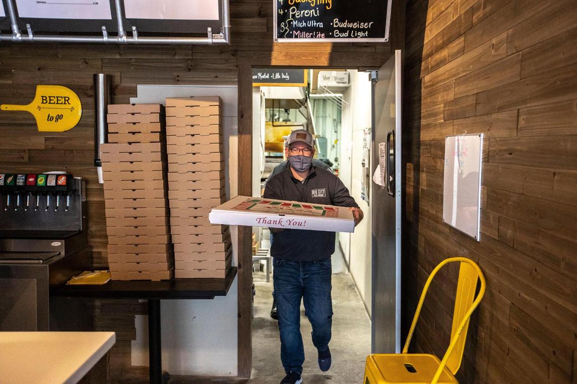 Curtis Gordon carries a boxed-up Big Bambino pizza from the kitchen Jan. 21 at Big City Pizza. The restaurant had to special order a box to house the pizza.