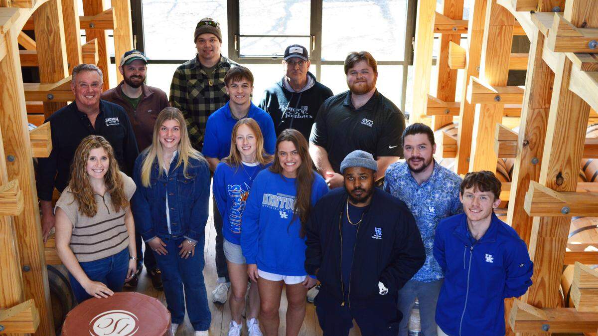 The Beam Institute’s inaugural Commercialization of Distilled Spirits course students pose for a group photo with honorary professor Herb Heneman, left, in JBBI’s on-site barrel house.