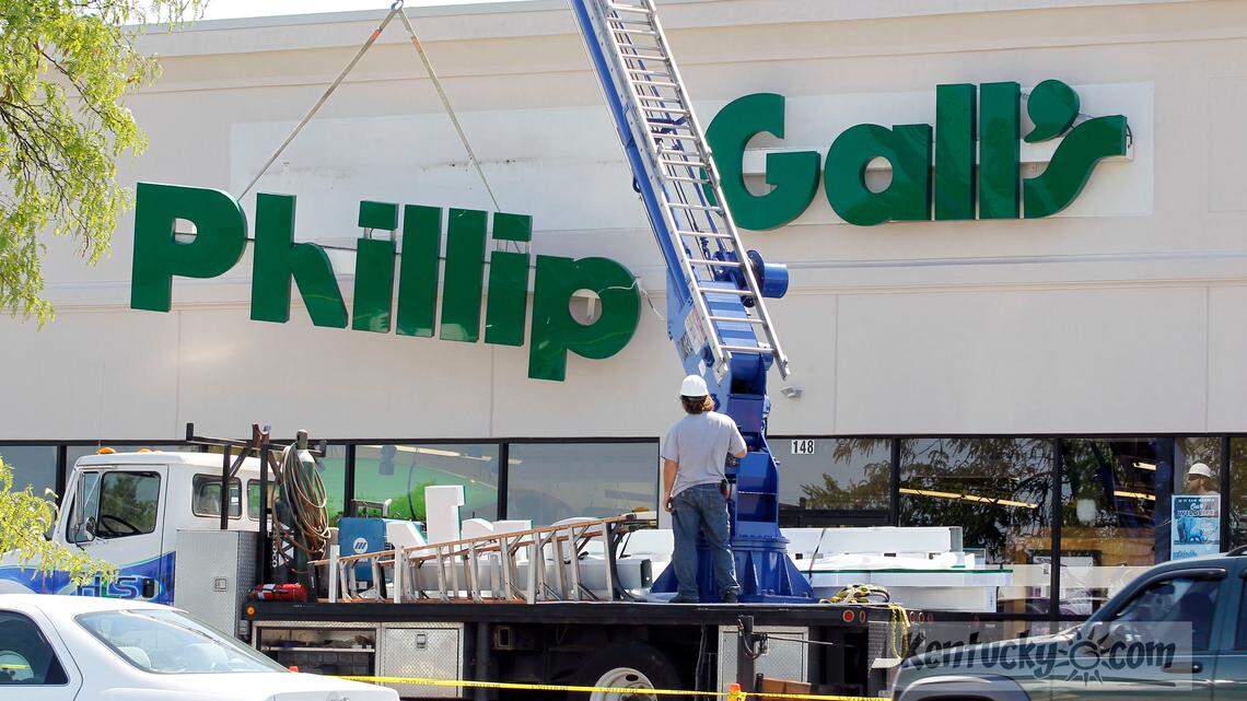 Matt Noschang, with Holthaus Lackner Signs, removed the old Phillip Gall's sign before installing a new Benchmark Outdoor Outfitters sign in the Woodhill shopping center in Lexington, Ky., Wednesday, June 27, 2012. Benchmark Outdoor Outfitters, owned by Northern Kentucky couple Burke and Stephanie Herron, already owns the Phillip Gall store, but changed the sign today. Benchmark plans to be more proactive in offering customers instruction and information on how to use the outdoorsy goods they sell. Photo by Charles Bertram | Staff
