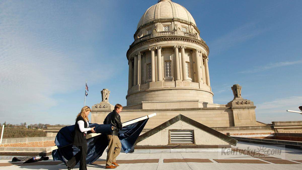 Carol Mitchell, left, and Frank Goins carried a banner on the rooftop of the State Capitol in Frankfort, Ky., on Dec. 9, 2011. Gov. Steve Beshear and Lt. Gov.-elect Jerry Abramson were sworn in to office during a full day of festivities on Dec. 13. Photo by Pablo Alcala | Staff