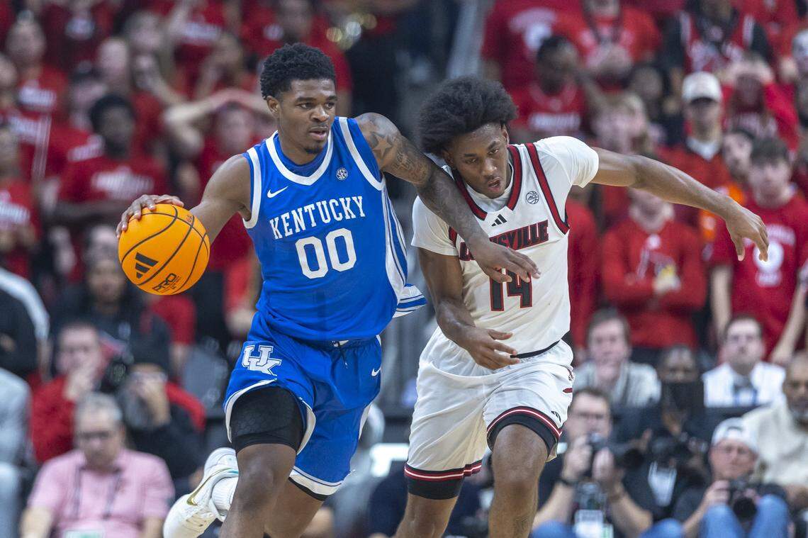 Kentucky guard Otega Oweh (00) drives the ball as Louisville guard Adrian Wooley (14) defends during Tuesday’s game at the KFC Yum Center in Louisville.