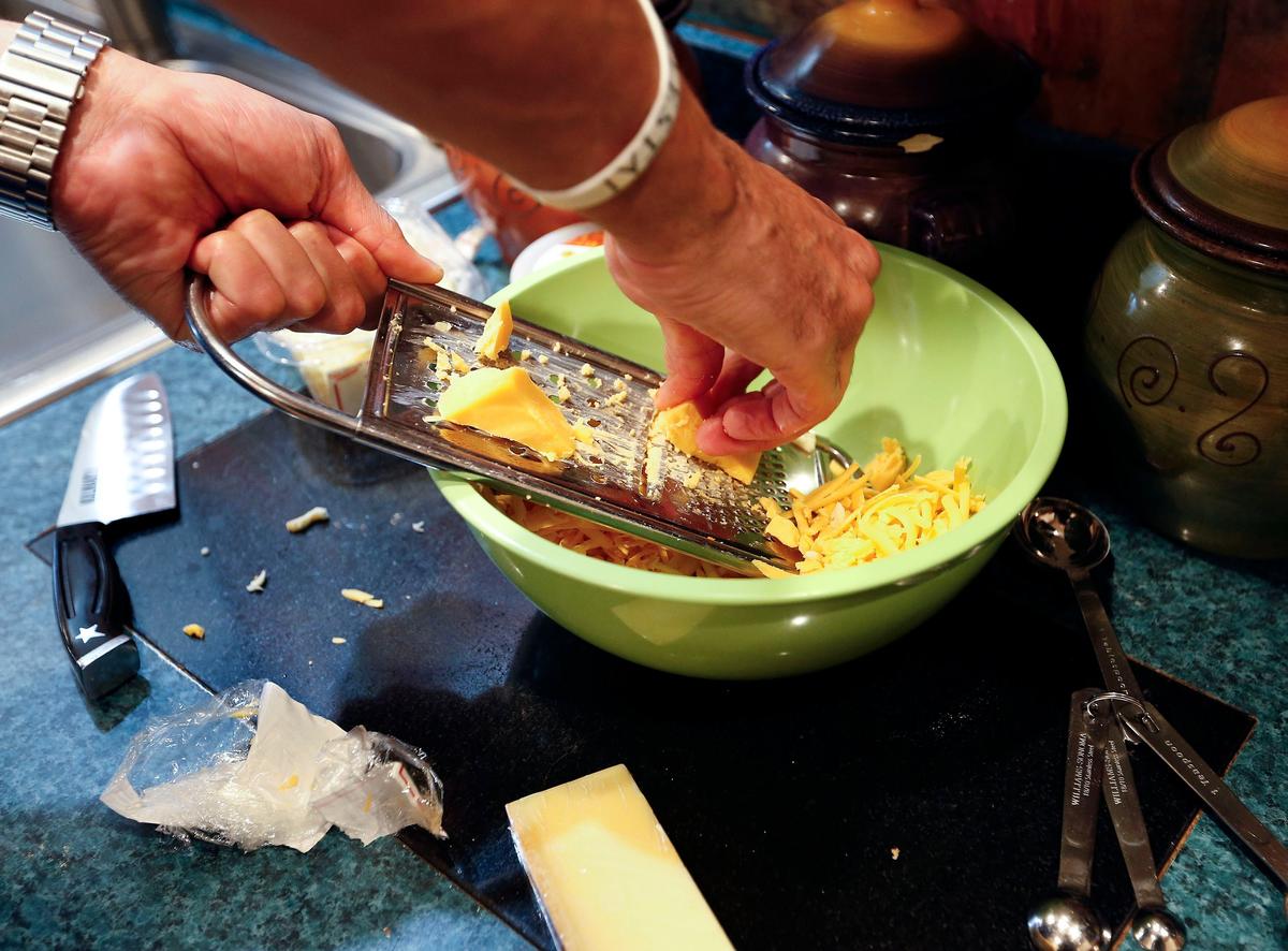 Former University of Kentucky basketball player Kenny “Sky” Walker mixes gruyere, parrano, cheddar and muenster for his mac and cheese sauce.
